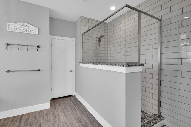 full bathroom with recessed lighting, baseboards, walk in shower, and wood finished floors