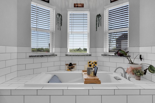 full bathroom featuring plenty of natural light and a bath