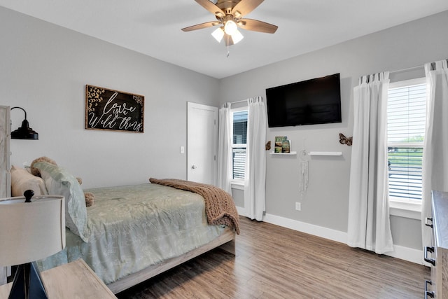 bedroom featuring baseboards, a ceiling fan, and wood finished floors