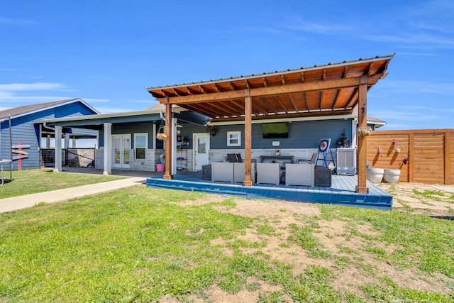rear view of property featuring a patio, french doors, fence, and a lawn