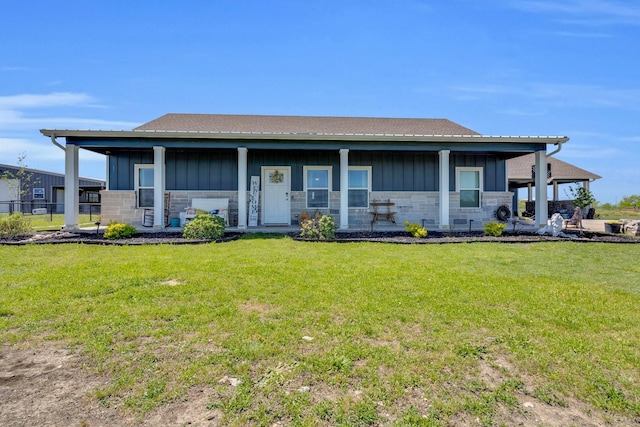 view of front facade with a front yard, board and batten siding, and stone siding