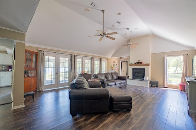 living room with dark wood-type flooring, ceiling fan, visible vents, and a wealth of natural light