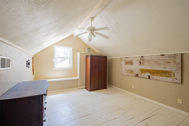 bonus room with light wood finished floors, a textured ceiling, vaulted ceiling, and ceiling fan