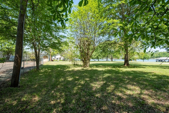 view of yard featuring a water view and fence