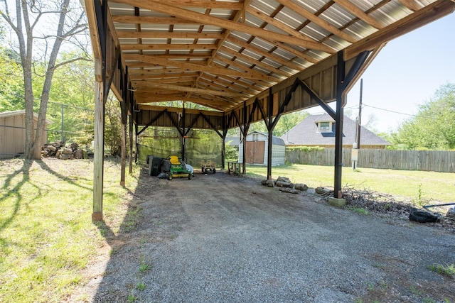 view of car parking with a storage shed and fence