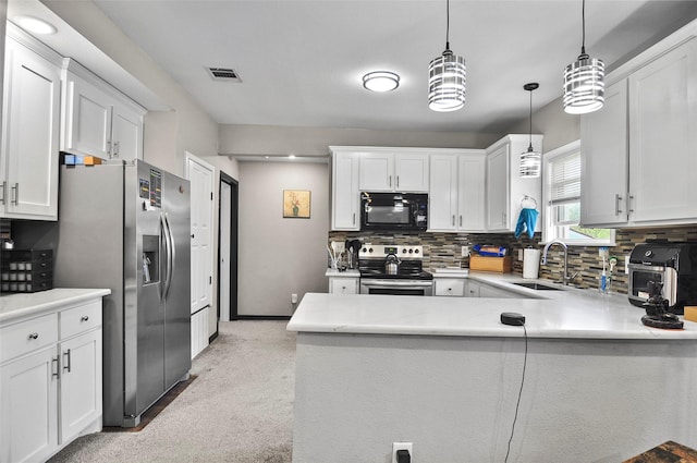 kitchen featuring a peninsula, a sink, backsplash, and appliances with stainless steel finishes