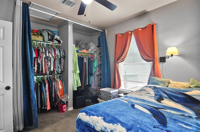carpeted bedroom featuring visible vents, a ceiling fan, attic access, and a closet