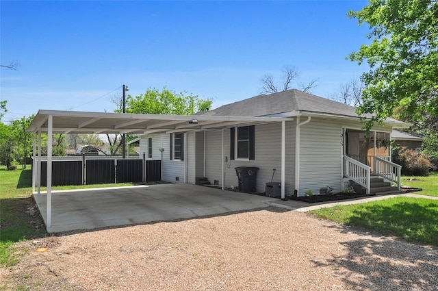 view of front of home with a front lawn, an attached carport, driveway, and roof with shingles