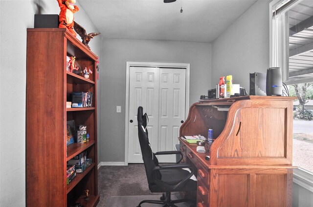 home office with dark carpet and baseboards