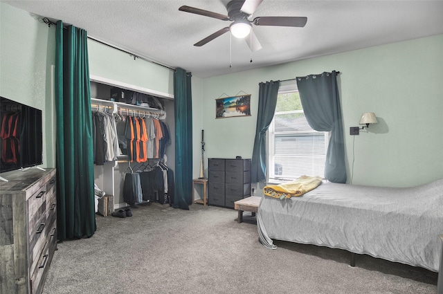 carpeted bedroom featuring a closet, a ceiling fan, and a textured ceiling