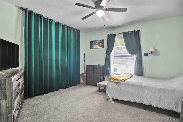 carpeted bedroom with a textured ceiling and a ceiling fan
