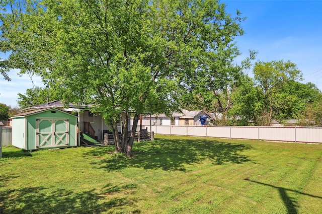 view of yard with an outdoor structure, fence, and a shed