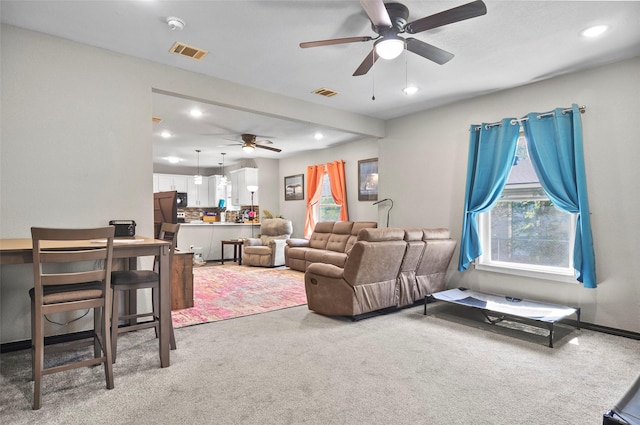 living room featuring recessed lighting, visible vents, light colored carpet, and a ceiling fan