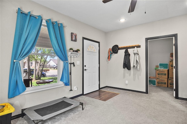 carpeted entryway with baseboards and a ceiling fan
