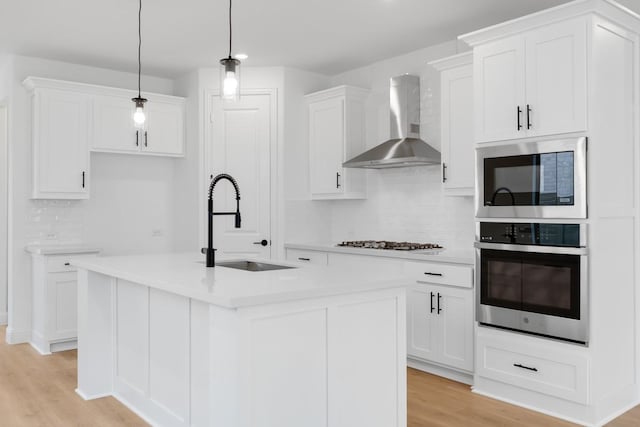1525 Ginger Ln, Argyle, TX 76226 - kitchen with light wood-style flooring, appliances with stainless steel finishes, wall chimney range hood, backsplash, and a sink