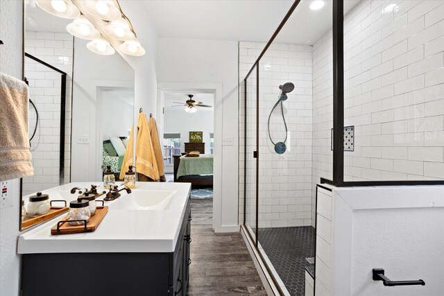 500 E Criner St, Grandview, TX 76050 - ensuite bathroom featuring wood finished floors, a tile shower, connected bathroom, vanity, and a ceiling fan