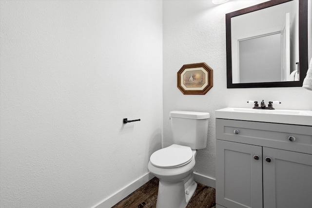 500 E Criner St, Grandview, TX 76050 - half bathroom featuring a textured wall, baseboards, toilet, wood finished floors, and vanity