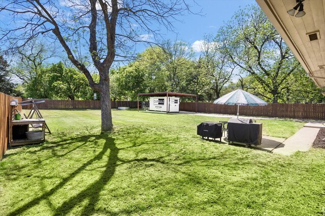500 E Criner St, Grandview, TX 76050 - view of yard featuring an outdoor structure, a fenced backyard, a carport, and a storage shed