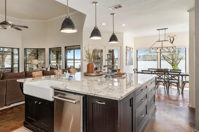 kitchen featuring visible vents, a sink, open floor plan, ceiling fan, and a wealth of natural light
