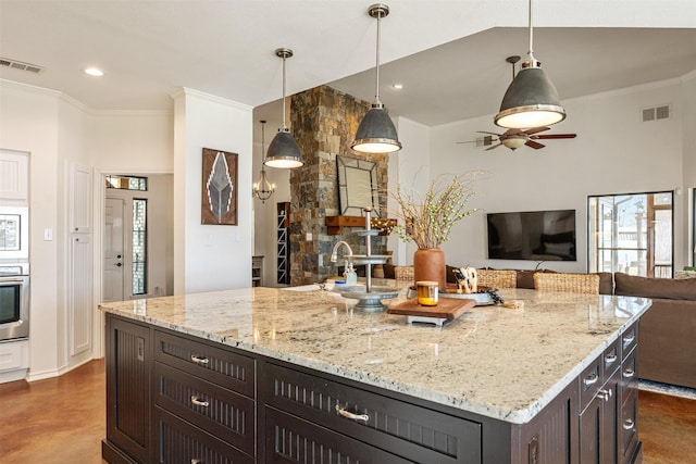 kitchen featuring open floor plan, visible vents, oven, and crown molding