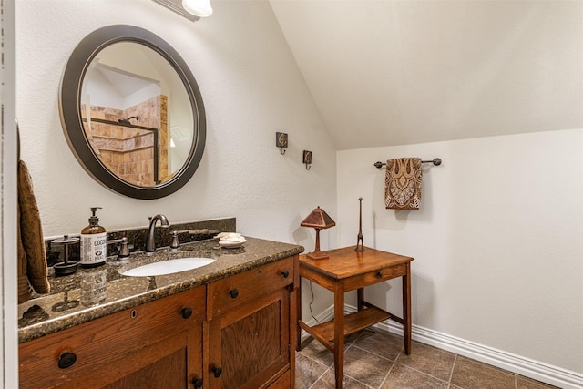 full bath featuring vanity, baseboards, tile patterned flooring, tiled shower, and lofted ceiling