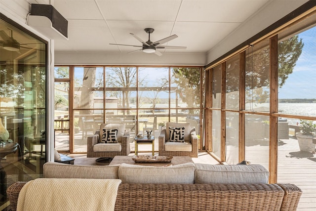 sunroom / solarium featuring an outdoor living space, ceiling fan, and a water view