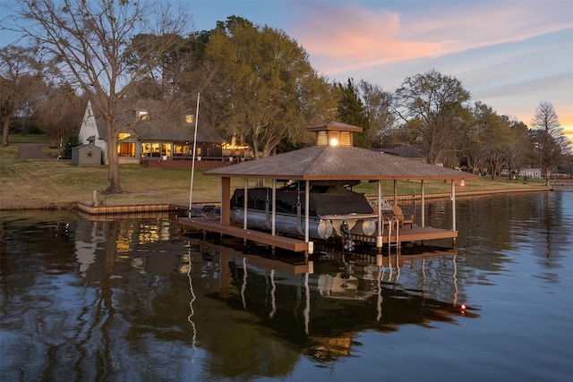 dock area with a water view, a yard, and boat lift