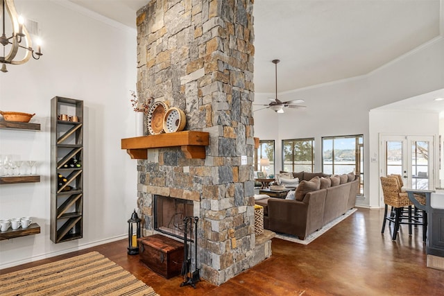 living room with ceiling fan with notable chandelier, a fireplace, ornamental molding, and baseboards