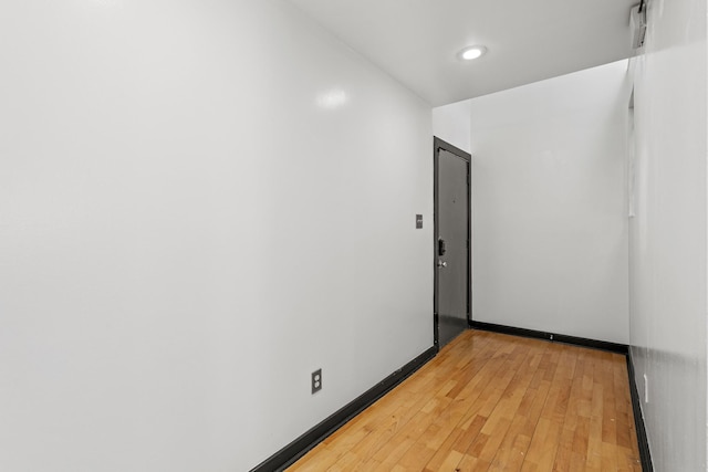 spare room featuring light wood-style floors, baseboards, and recessed lighting