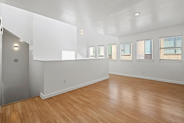 unfurnished room with baseboards, light wood finished floors, and recessed lighting