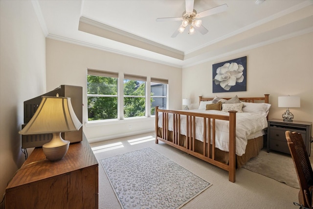 bedroom featuring ornamental molding, carpet floors, a ceiling fan, and a tray ceiling