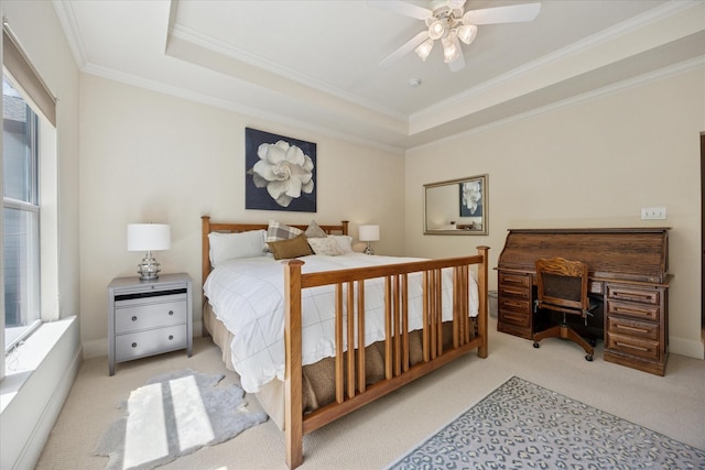 carpeted bedroom with a raised ceiling, crown molding, and ceiling fan