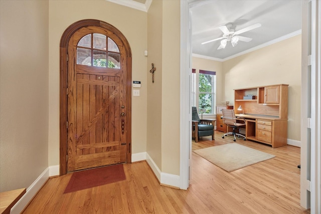 foyer entrance featuring light wood finished floors, baseboards, crown molding, and ceiling fan