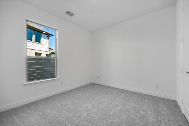 carpeted empty room with visible vents and baseboards