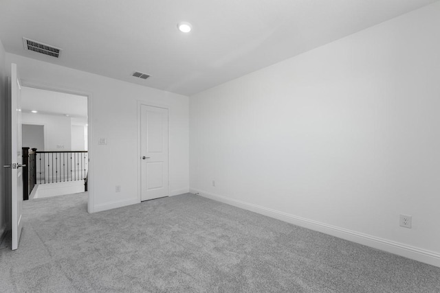carpeted empty room with recessed lighting, visible vents, and baseboards