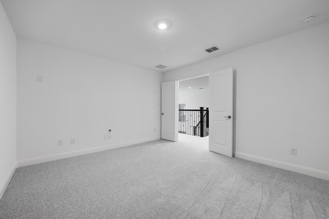 carpeted empty room featuring visible vents and baseboards
