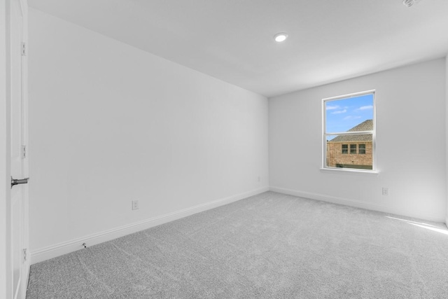 carpeted spare room featuring recessed lighting and baseboards