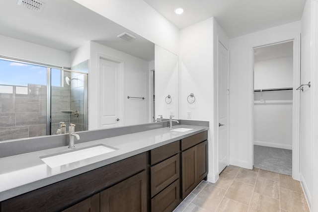 full bathroom with a sink, a stall shower, double vanity, and visible vents