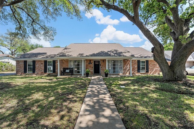 ranch-style house with brick siding and a front yard