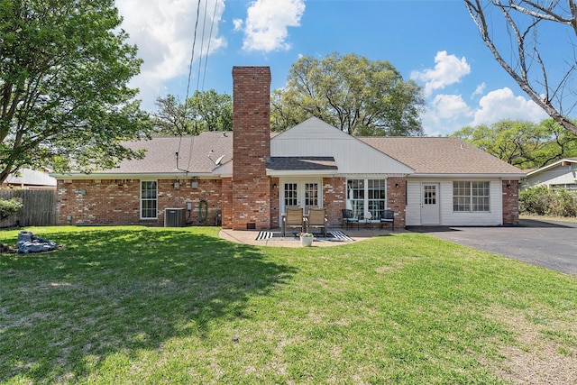 back of house featuring central AC, a patio area, a lawn, fence, and brick siding