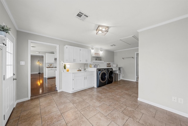 washroom featuring a sink, visible vents, washer and clothes dryer, and crown molding