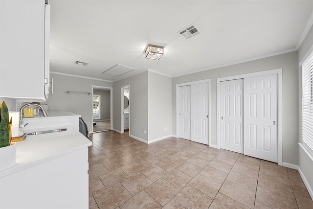 clothes washing area featuring plenty of natural light, visible vents, baseboards, and a sink