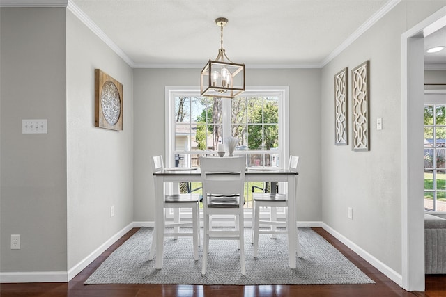 dining space featuring a chandelier, dark wood-type flooring, baseboards, and ornamental molding