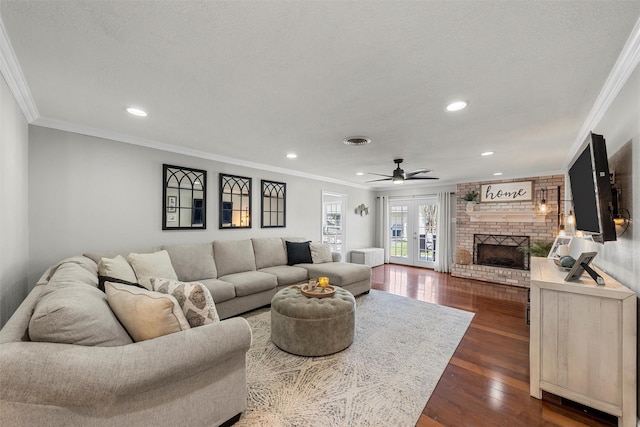 living area with crown molding, visible vents, recessed lighting, and a brick fireplace