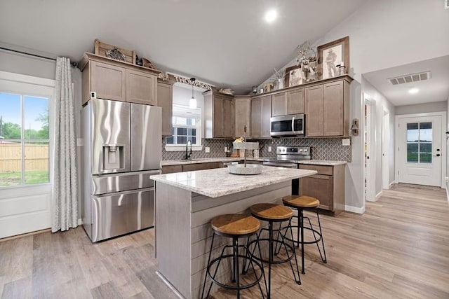 kitchen featuring stainless steel appliances, tasteful backsplash, visible vents, and a sink