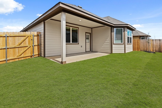 rear view of house featuring a patio, a fenced backyard, a gate, and a lawn