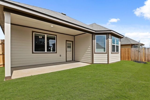 back of house featuring a yard, fence, and a patio area
