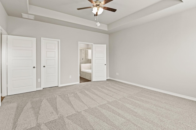 5045 Cervinae Rd, Fort Worth, TX 76036 - unfurnished bedroom with a tray ceiling, baseboards, carpet, and connected bathroom