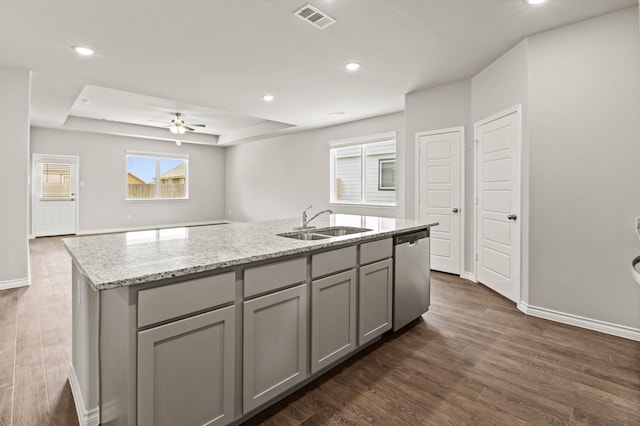 kitchen with gray cabinetry, visible vents, a raised ceiling, dishwasher, and a sink