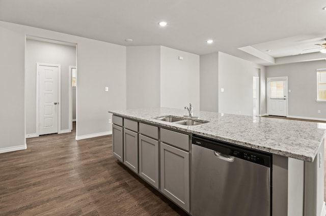 kitchen with an island with sink, gray cabinets, light stone counters, dishwasher, and a sink